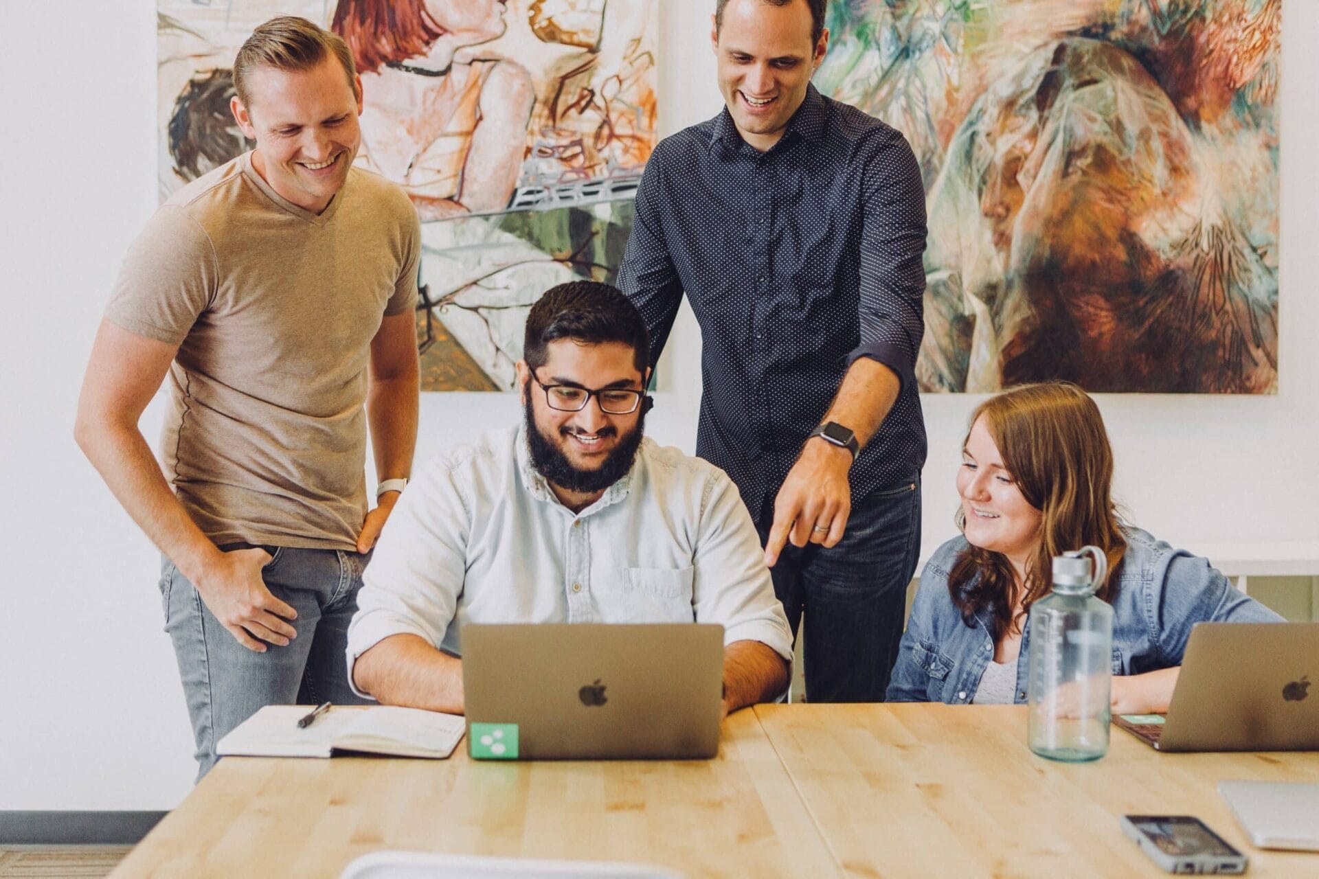 Security team of a business gathered around laptop viewing new serverless security cameras